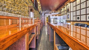 Eine Bar mit Holzbänken und einer Steinwand.