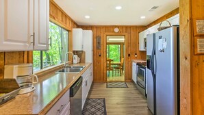 A kitchen with wooden paneling, white cabinets, a coffee maker, and a refrigerator. - Secluded 'mountain Home' 12 Mi to Tsali Area (Robbinsville)