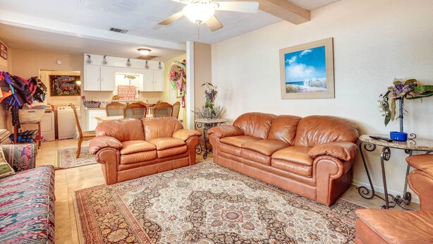 A spacious living room with leather sofas, a patterned rug, and a ceiling fan. - 'the Whacky Shack' Family Cabin w/ Fire Pit! (Trinity)