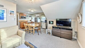 A compact living space with a dining area, kitchenette, and a TV. - Sunset & Water Views in WWC on Sunset Lake (Wildwood Crest)