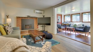 A modern living room with a fireplace, a flat-screen TV, and a comfortable seating area with a sofa and chairs. - Woodstock Getaway w/ Hot Tub ~ 2 Mi to Dtwn! (Woodstock)