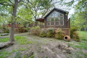 A cabin with a wooden deck, large windows, and a fenced yard. - Winery Cabin in Fredericksburg w/ Wraparound Deck! (Fredericksburg)