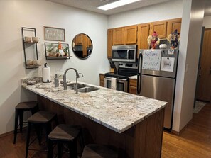 With the oversize countertop and the barstools, this makes a perfect spot to have some breakfast with you coffee in the mornings, Don't mind the fall Nomes or scare crow's they already had breakfast. - Penthouse at Notch (First Responder Owner) (Reeds Spring)