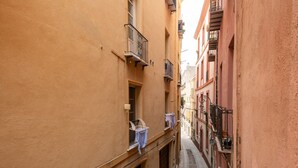 A narrow street with buildings on either side, featuring balconies with clothes hanging out to dry. - Castello Loft Heaven (Cagliari)