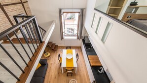 A modern loft-style apartment with a dining area, kitchen, and a staircase. - Castello Loft Heaven (Cagliari)