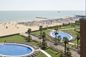 A resort with a pool area, beach, and ocean view.