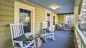A porch with rocking chairs and a bench, wooden railings, and a covered area with a ceiling light. - 'carefree Cottage' < 6 Mi to Downtown Asheville! (Asheville)