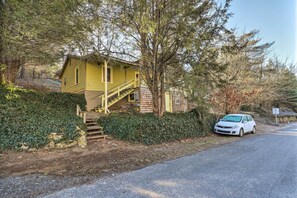 A yellow house with a staircase leading to the front door, surrounded by trees and a white car parked in front. - 'carefree Cottage' < 6 Mi to Downtown Asheville! (Asheville)
