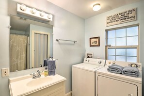 A bathroom with a vanity, mirror, sink, and a wall-mounted light fixture. - 'carefree Cottage' < 6 Mi to Downtown Asheville! (Asheville)