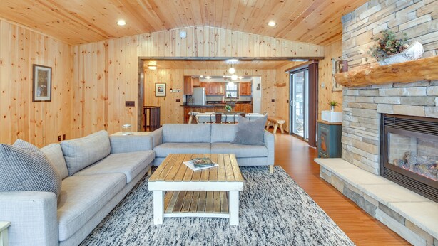 Ein gemütliches Blockhaus-Interieur mit Wohnzimmer, Küche und Kamin.