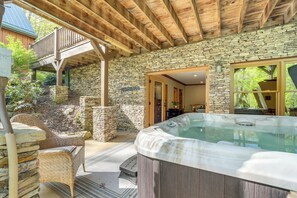 A hot tub under a wooden pergola, stone walls, and a wicker chair. - Hot Tub & Fire Pit: Secluded Gem in Franklin (Franklin)