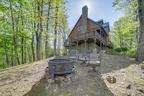 A rustic cabin with a stone chimney, wooden deck, and outdoor seating area. - Hot Tub & Fire Pit: Secluded Gem in Franklin (Franklin)