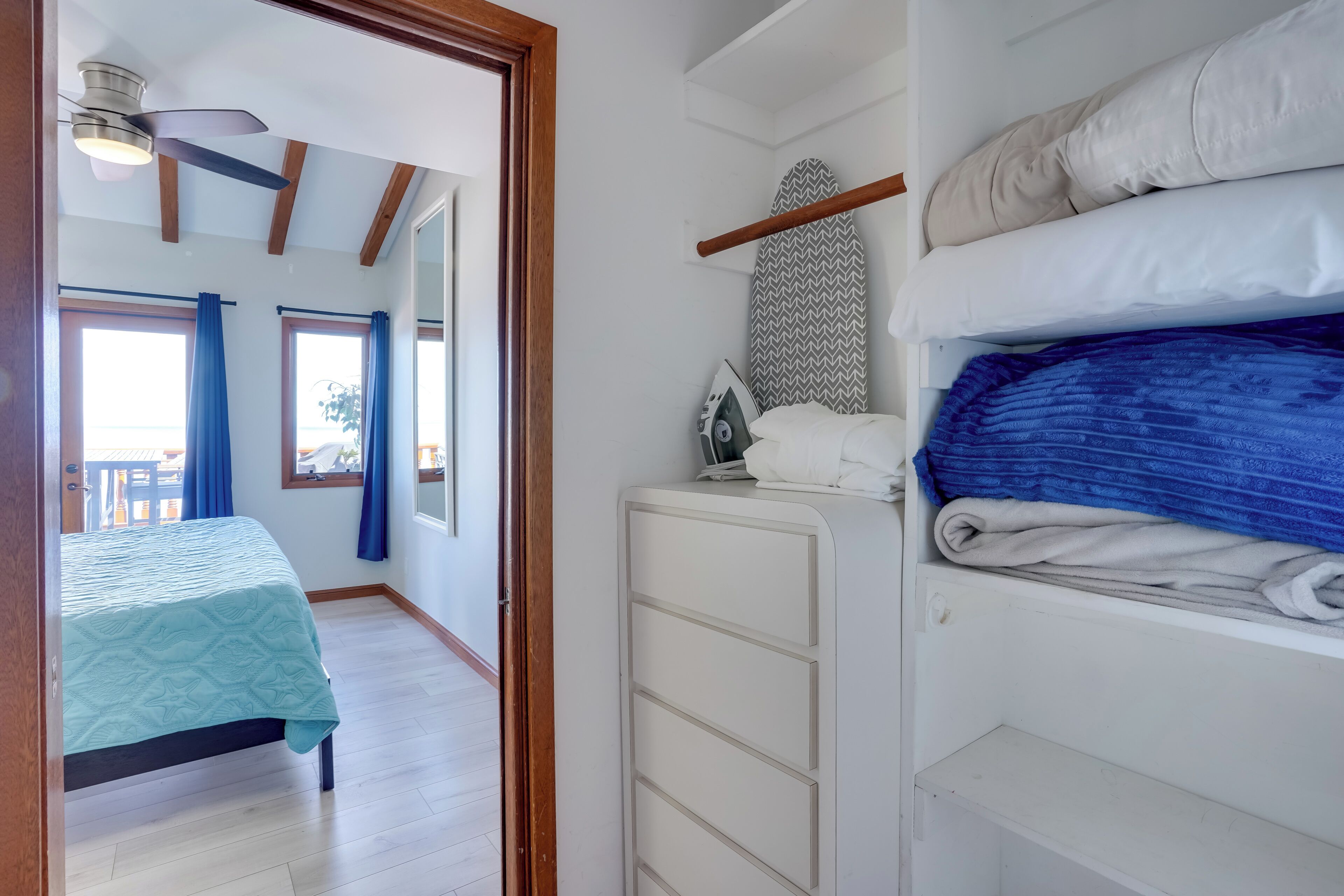Een slaapkamer met een bed, een kledingkast en een plafondventilator.