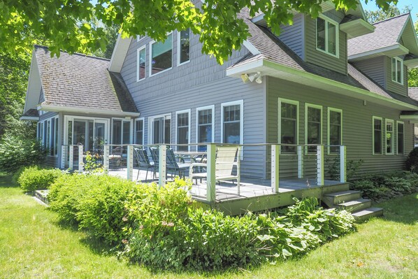 A two-story house with a covered porch and a small deck.