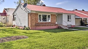 A single-story house with a red roof and white siding, a satellite dish, and a well-maintained lawn. - Ashton Escape w/ Yard: 56 Mi to West Yellowstone! (Ashton)