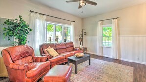 A spacious living room with a leather sofa, a coffee table, and a ceiling fan. - Beautifully Restored Farmhouse in Marshall! (Martinsville)