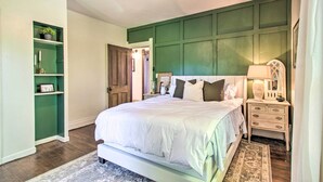 A bedroom with a bed, nightstands, a dresser, a ceiling fan, and built-in shelving. - Beautifully Restored Farmhouse in Marshall! (Martinsville)