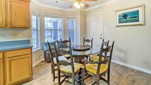 A dining area with a round table, wooden chairs, and a ceiling fan. - Blue Ridge Vacation Rental w/ Game Room! (Blue Ridge)