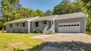 A two-story house with a covered front porch, a garage, and a well-maintained lawn. - Charlotte Vacation Rental w/ Private Hot Tub! (Charlotte)