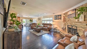 A spacious living room with a fireplace, leather sofas, and a stone accent wall. - Vista Home w/ Pool ~ 11 Mi to Tamarack State Beach (Vista)