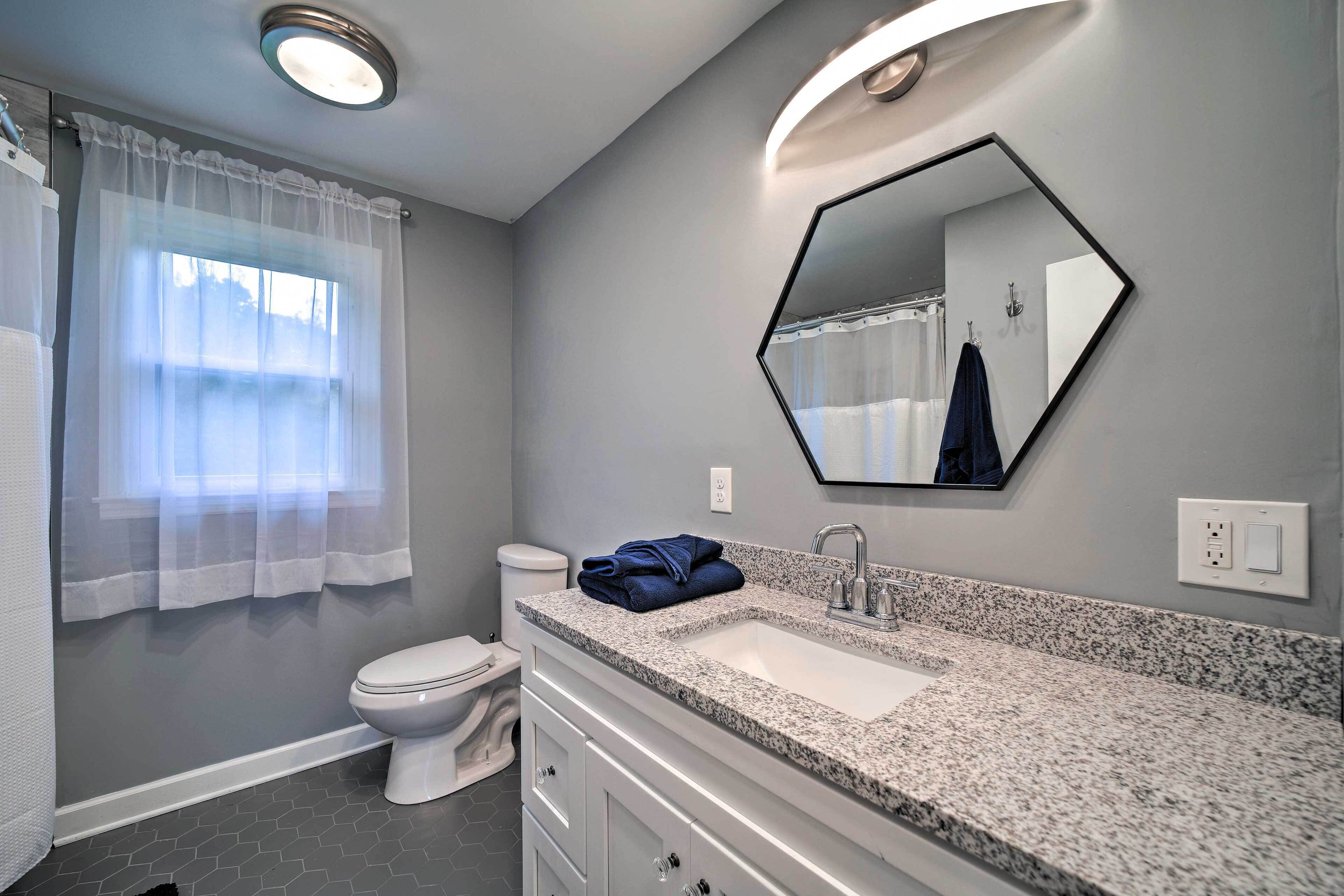 A bathroom with a toilet, sink, and mirror.