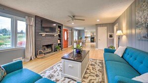A living room with a fireplace, blue sofas, a coffee table, and a view of the outdoors. - Home w/ Yard: 8 Mi to French Broad River Park (Asheville)