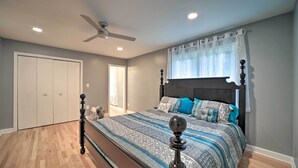A bedroom with a bed, a ceiling fan, a wardrobe, and a window with a curtain. - Home w/ Yard: 8 Mi to French Broad River Park (Asheville)