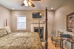 Un dormitorio con cama, chimenea, televisor y mesa de comedor.