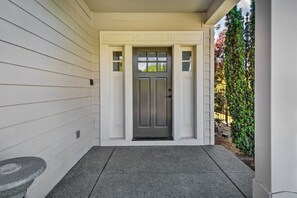 A front door with a dark gray color, a small window above it, and a stone bench to the left. - Charming Medford Getaway ~ 4 Miles to Downtown! (Medford)