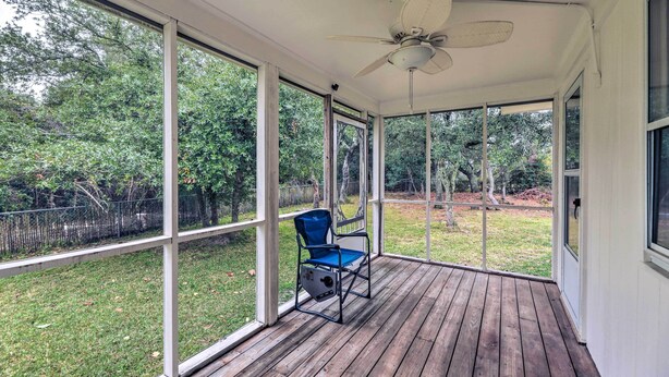 A covered porch with a ceiling fan, large windows, and a blue chair. - Coastal Retreat! Harkers Island Boating Base (Harkers Island)