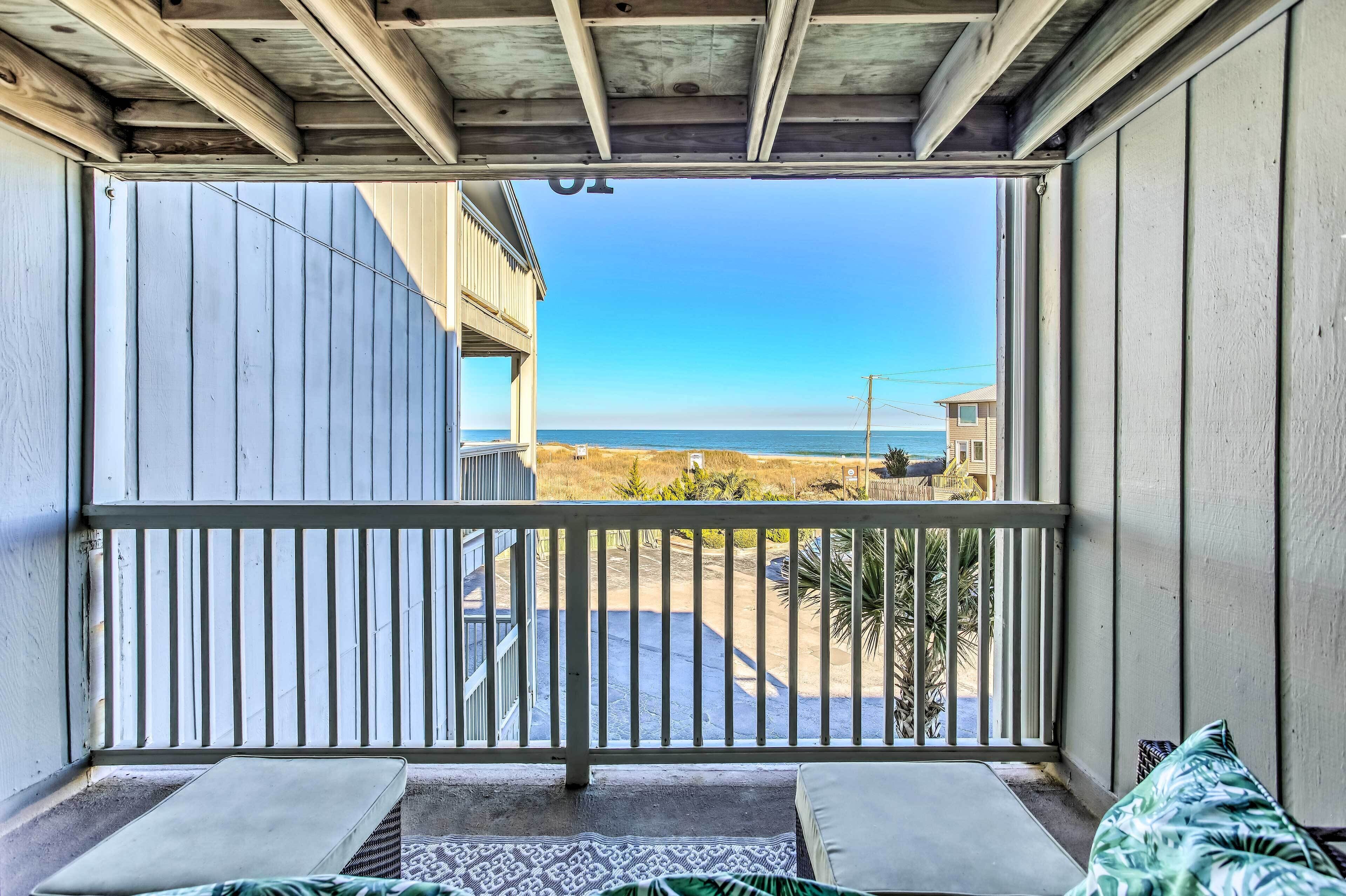 Un balcon avec vue sur la plage et l’océan.