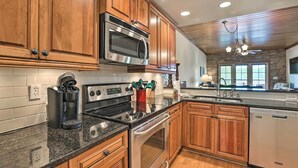 A kitchen with wooden cabinets, stainless steel appliances, granite countertops, and a built-in oven.