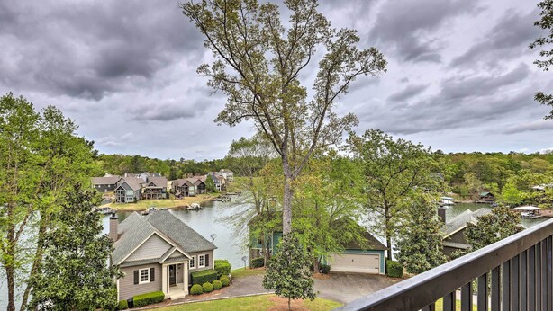 A residential area with houses, a lake, and a cloudy sky.