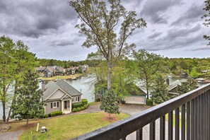 A residential area with houses, a lake, and a cloudy sky. - Lakefront Dadeville Condo w/ Community Boat Dock! (Dadeville)
