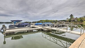 A marina with docked boats and a house in the background.