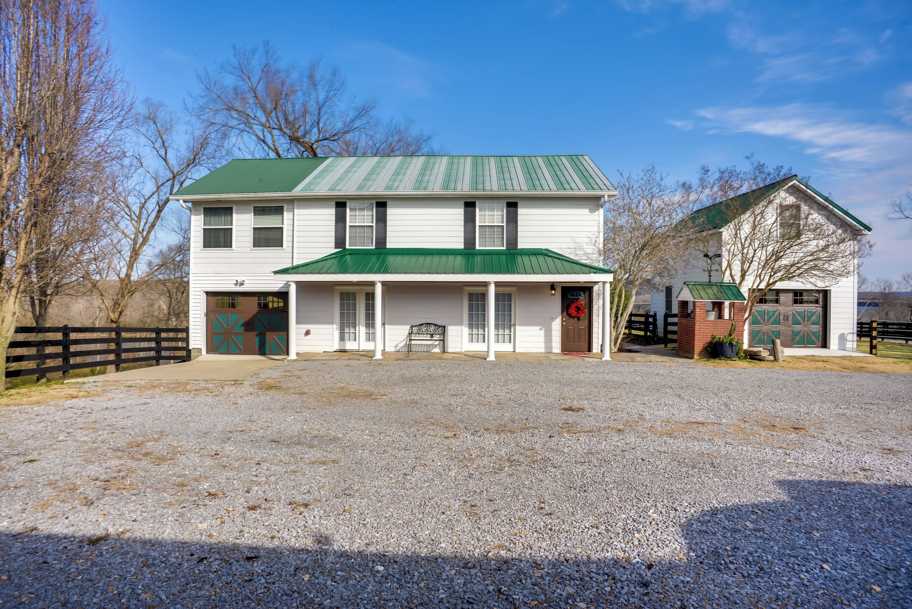 A two-story building with a green roof and a front porch.