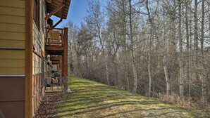 Ein hölzernes Gebäude mit überdachter Veranda und einem Weg, der durch einen Wald führt.