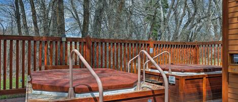Een houten terras met jacuzzi's en een houten omheining.