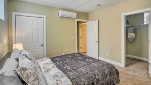 A bedroom with a bed, a door, an air conditioning unit, and a closet with a hanging rack. - ~ 2 Mi to Downtown - Cozy Cleveland Unit (Cleveland)