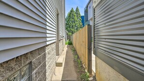 A narrow pathway between two buildings with siding and a wooden fence. - ~ 2 Mi to Downtown - Cozy Cleveland Unit (Cleveland)