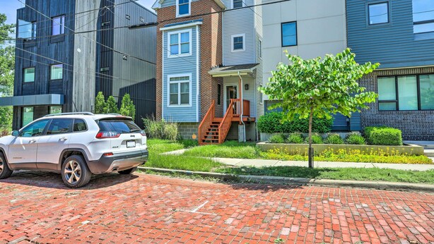 A modern multi-story residential building with a brick driveway and a white SUV parked in front. - ~ 2 Mi to Downtown - Cozy Cleveland Unit (Cleveland)