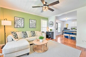 A living room with a sofa, coffee table, and artwork on the wall. - Cozy Bryson City Home w/ Fire Pit & Mtn Views! (Bryson City)