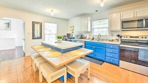 A kitchen with a central island, blue cabinets, and a microwave. - Cozy Bryson City Home w/ Fire Pit & Mtn Views! (Bryson City)