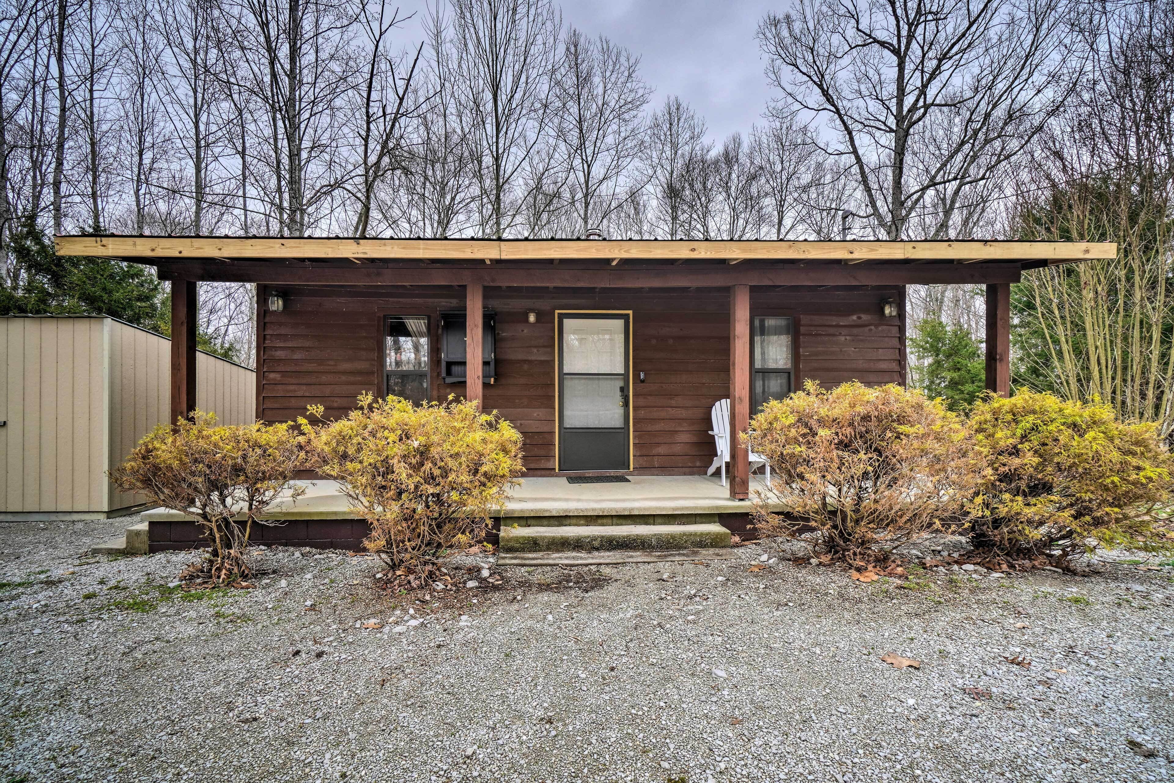 A small wooden cabin with a porch, a door, and a window.