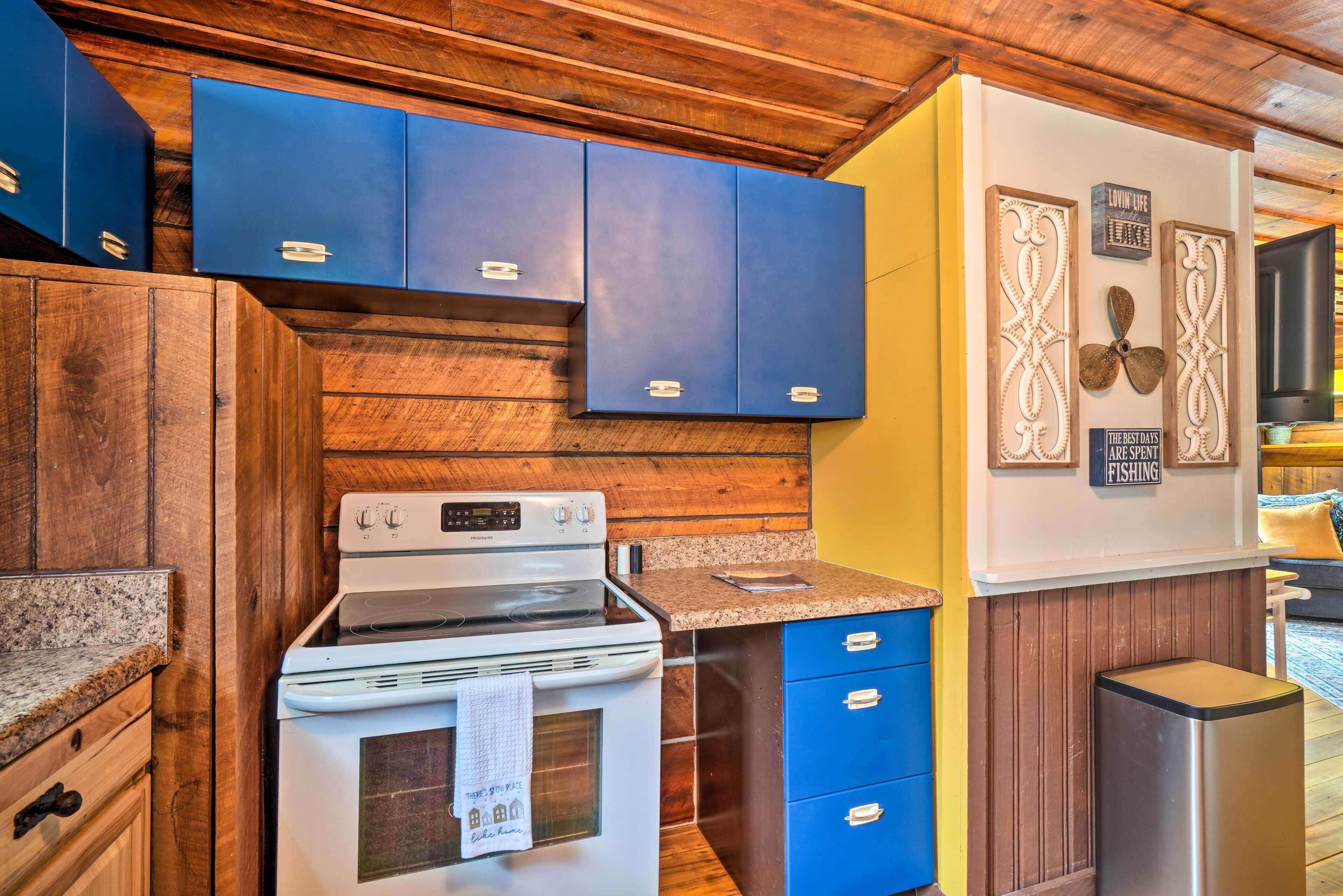 A kitchen with wooden cabinets, a white stove, and blue drawers.