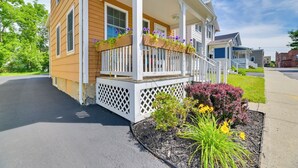 A two-story house with a porch, white railings, and flower boxes.
