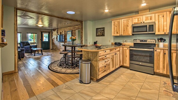 A spacious kitchen with wooden cabinets, a stainless steel oven, and a microwave.