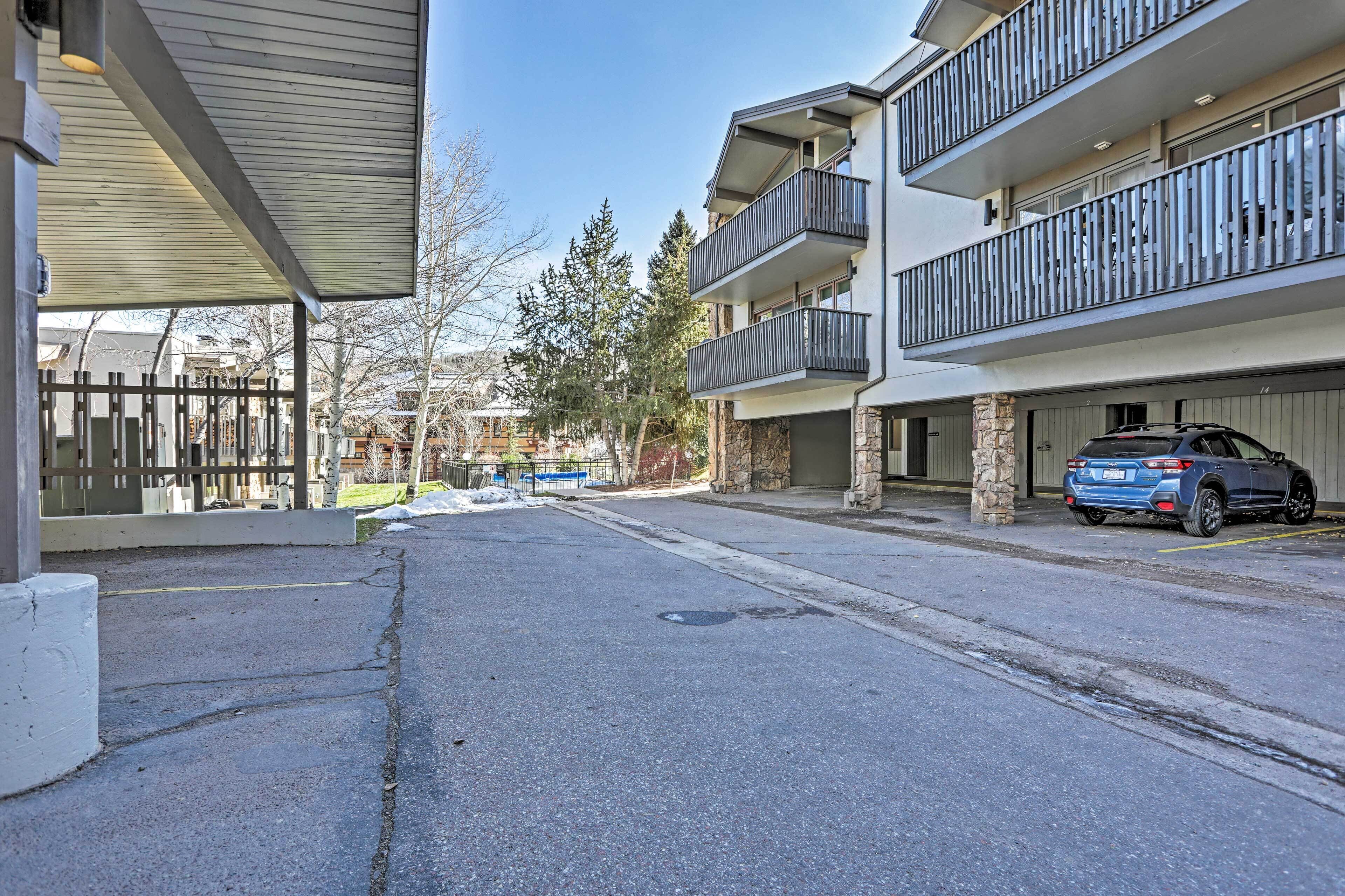 A multi-story residential building with balconies, a parking garage, and a clear sky.