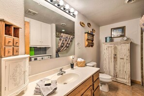 Classic bathroom with a large mirror, modern faucet, and decorative plates.