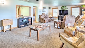 A cozy living room with a fireplace, comfortable seating, and a television. - Lakeside Retreat: Private Hot Tub, Walk to Lake (Elwood)